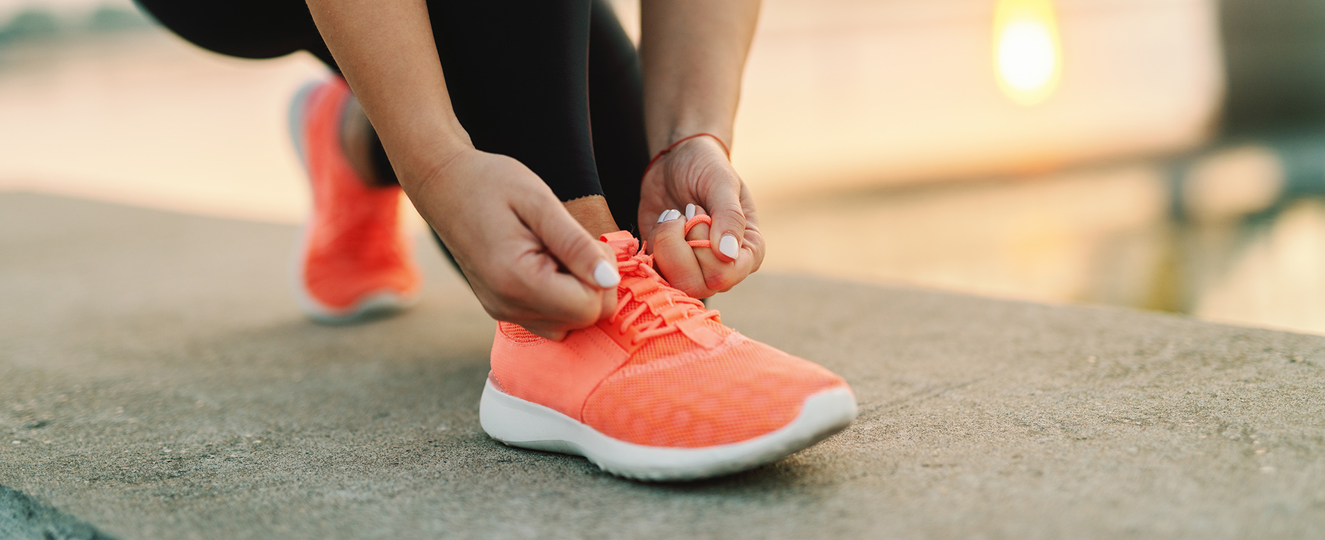 A person lacing up their shoe getting ready for a workout