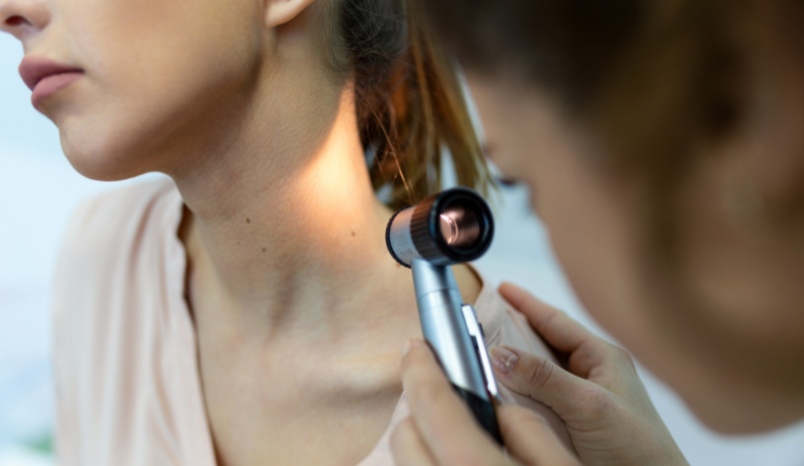 Dermatologist examines patient's skin.