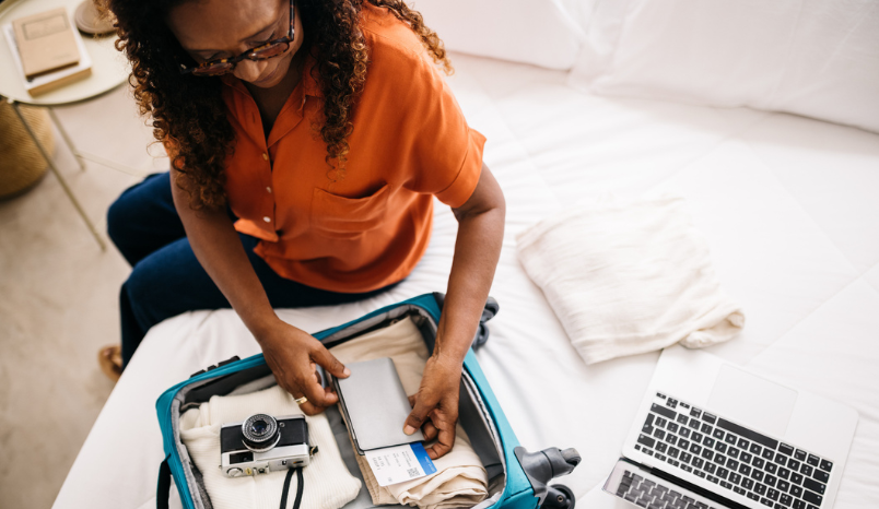 Retired woman packs suitcase.