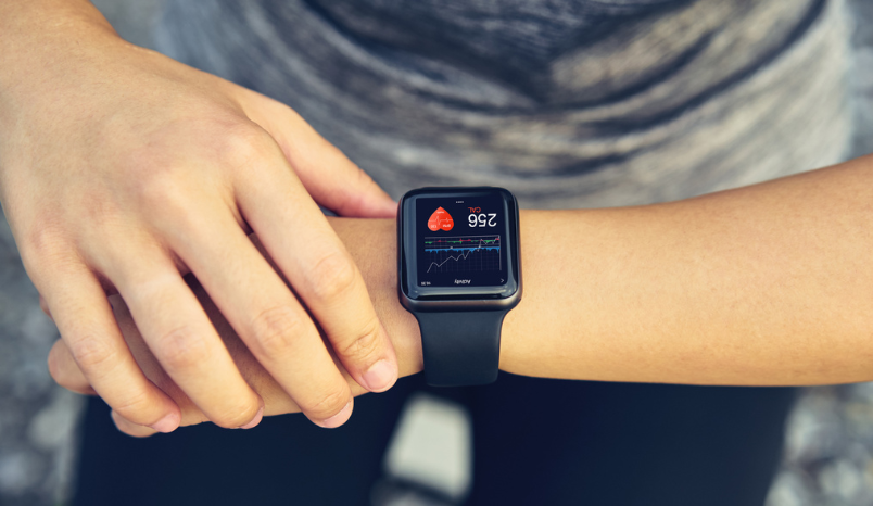 Person looks at smartwatch to check heart health.