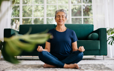 Older woman sits in lotus position while practicing yoga.