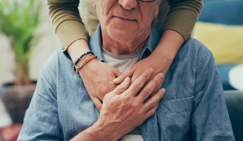 Person embraces older man.