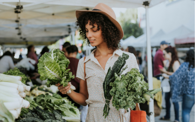 Woman looks at vegetable selection at local farmers market.