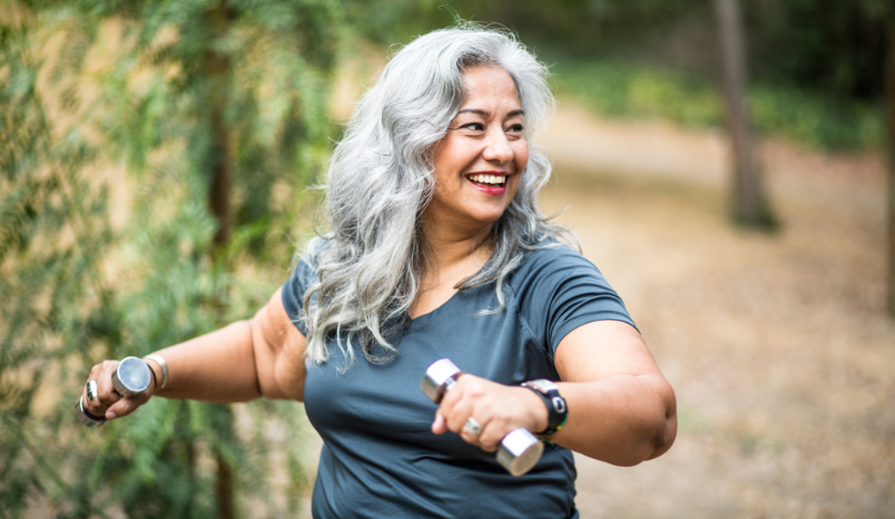 Older women lifts small weights.