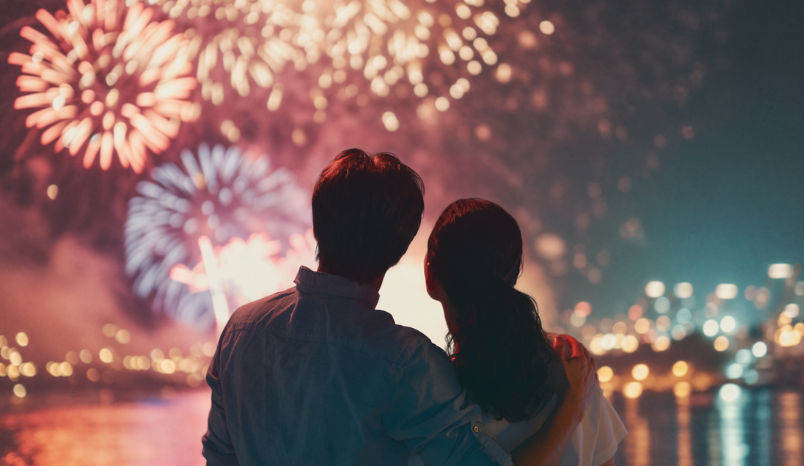 Couple watches a professional fireworks display.