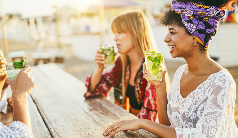 Women drink mocktails outside.