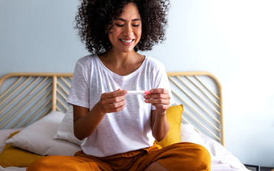 Smiling woman holds pregnancy test.