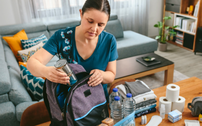 Woman prepares backpack for emergency.