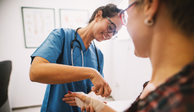 Nurse wraps patient's arm in guaze.