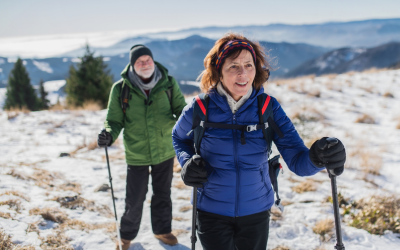 Older couple snowshoe on mountain.