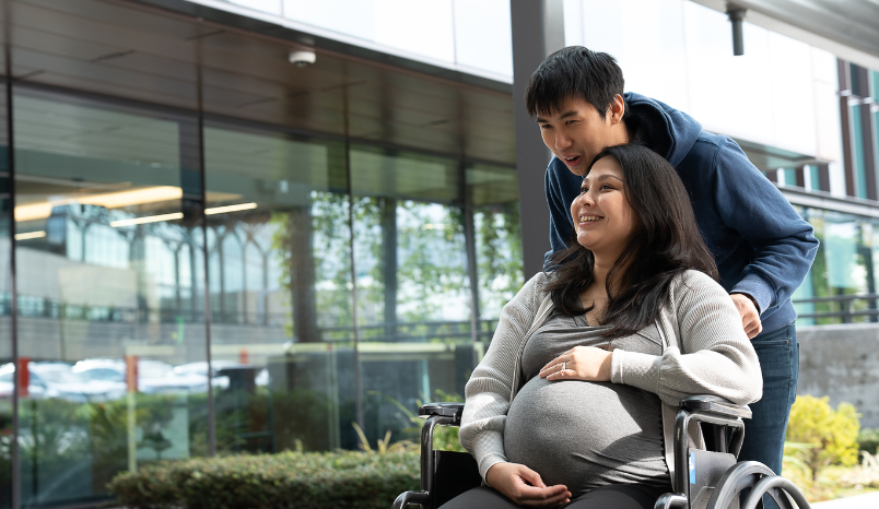 Pregnant woman and husband outside hospital.