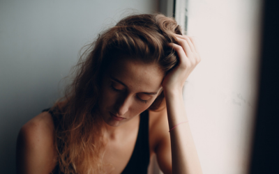 Woman runs hand through hair, appears distressed.