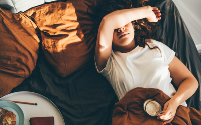 Fatigued woman holds coffee cup.