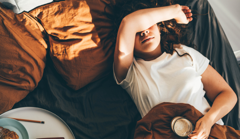 Woman is fatigued and holding coffee.