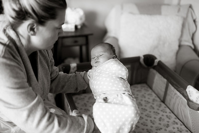 Mother placing baby in crib